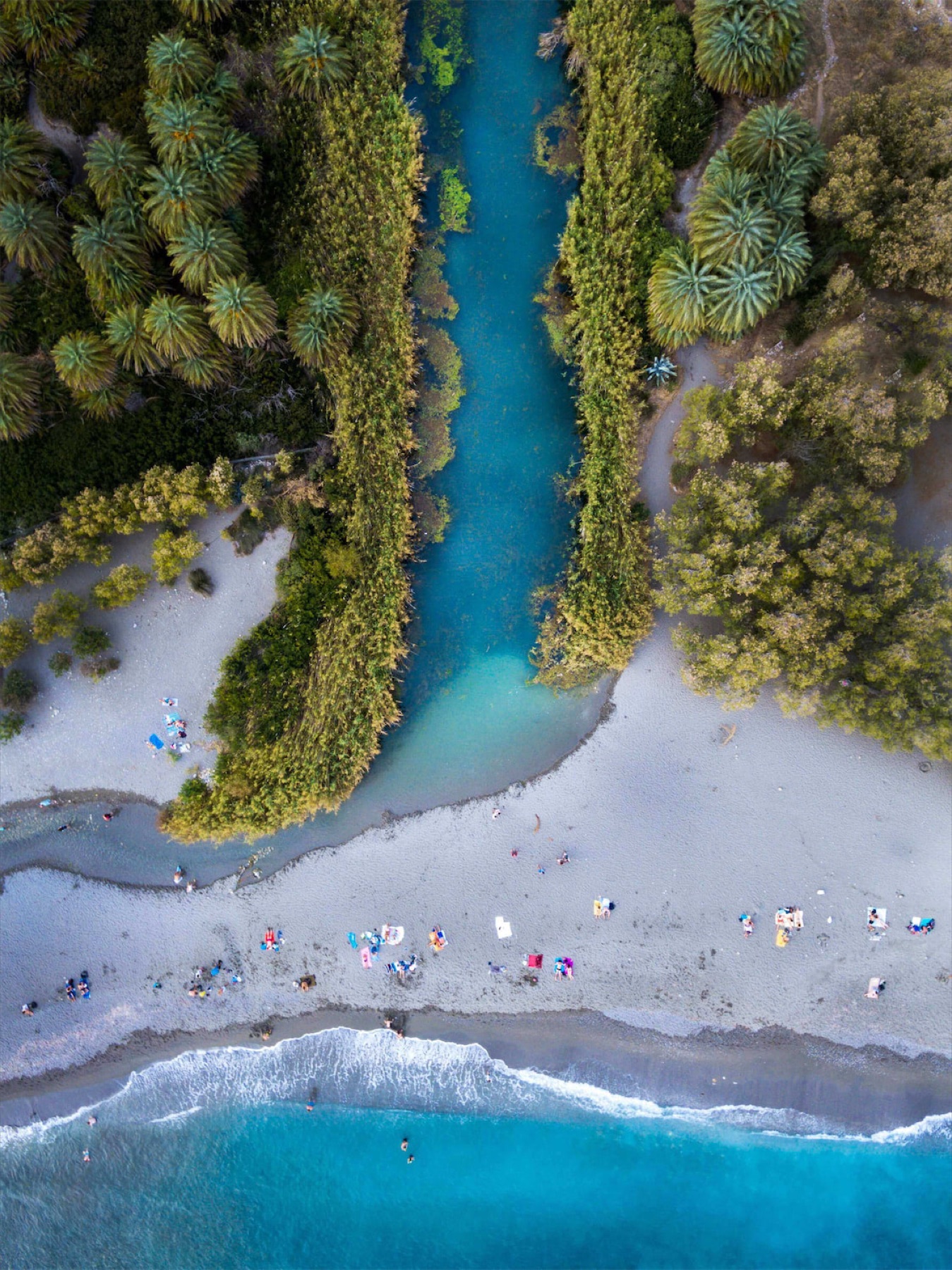 Aerial view of Preveli Beach, river, palms, and blue sea