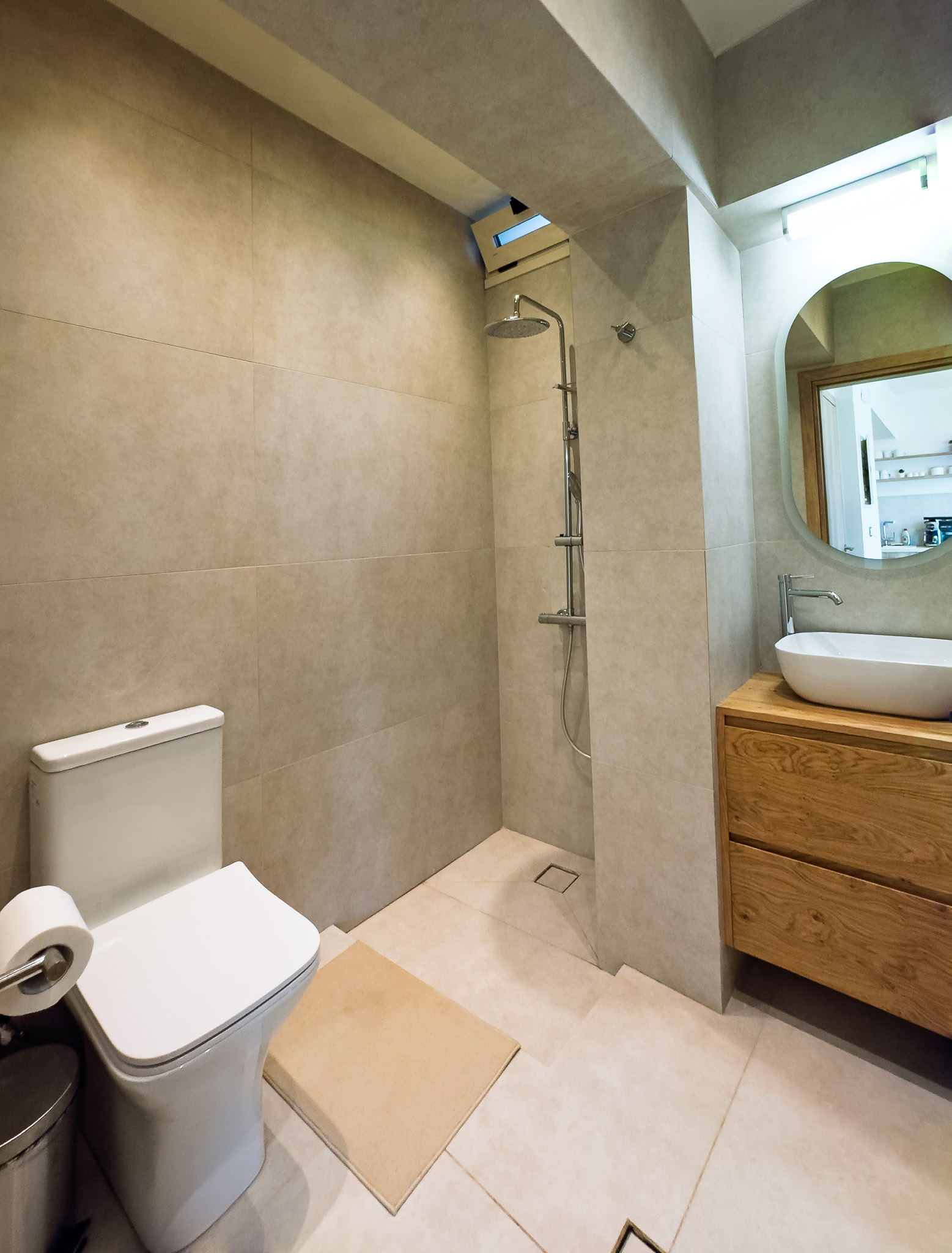 Vertical view of the bathroom with walk-in shower, sink, and mirror