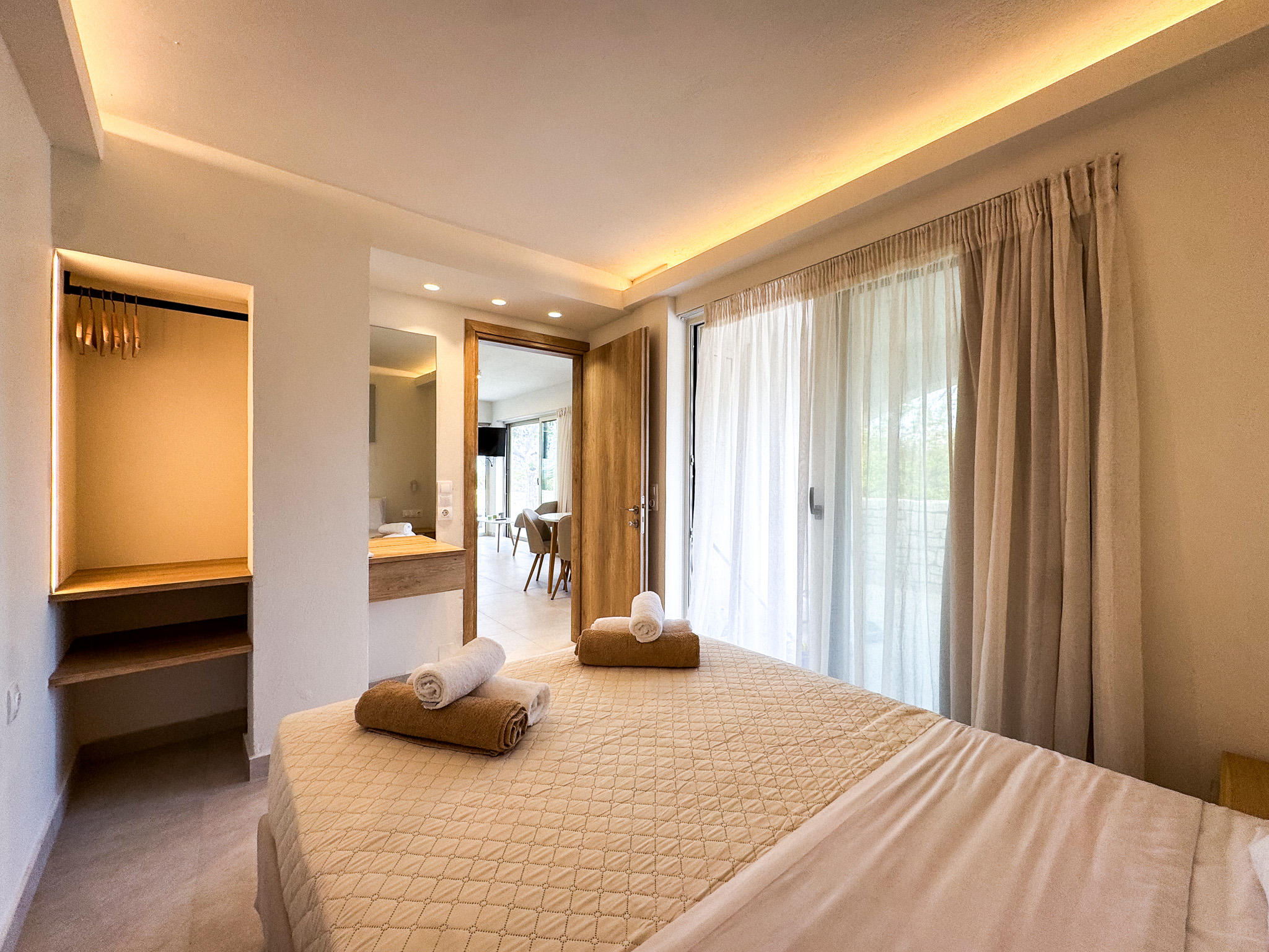 Queen bedroom at Nogal Retreat with towels and warm light