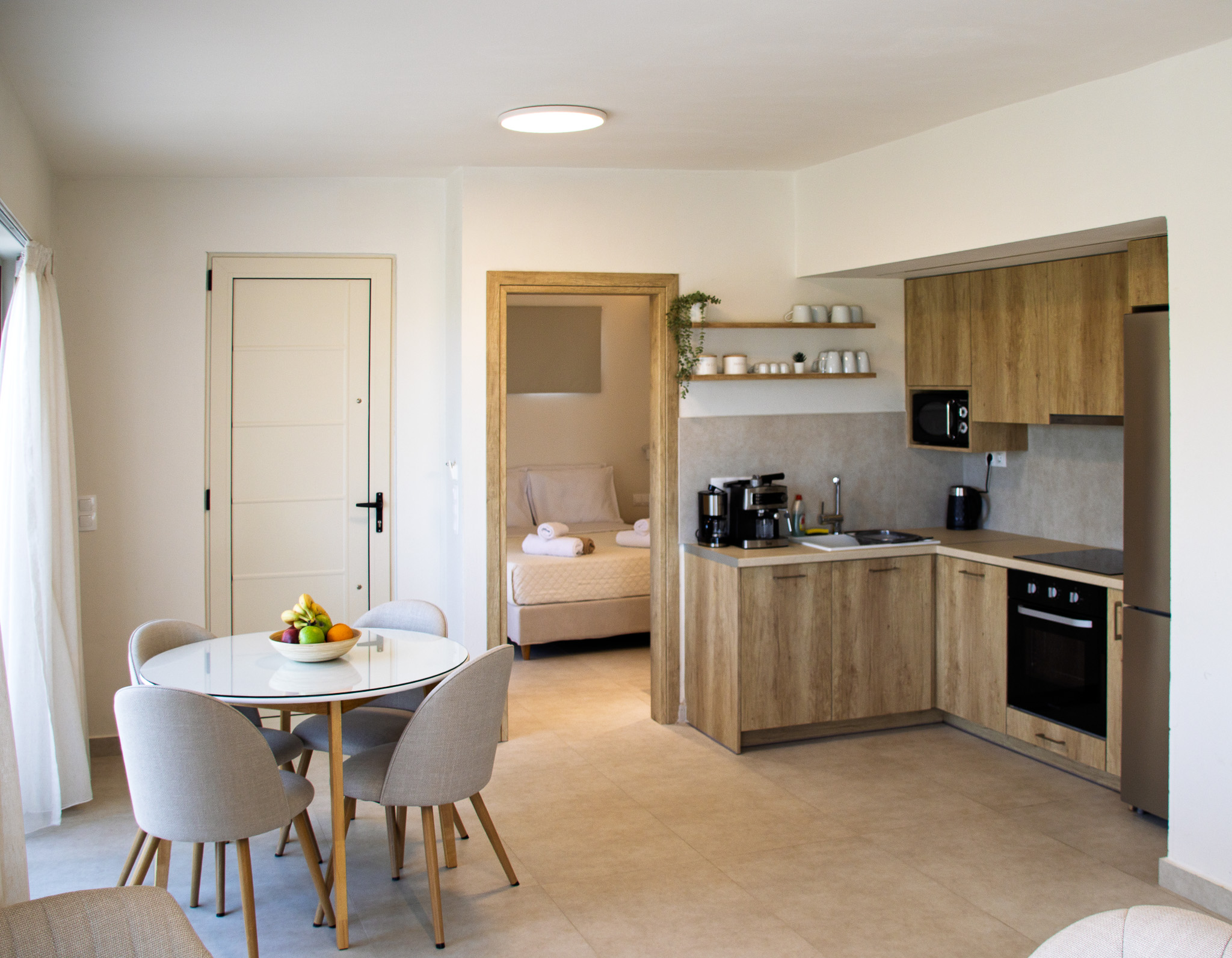 Kitchen and dining space with the bedroom visible through the doorway