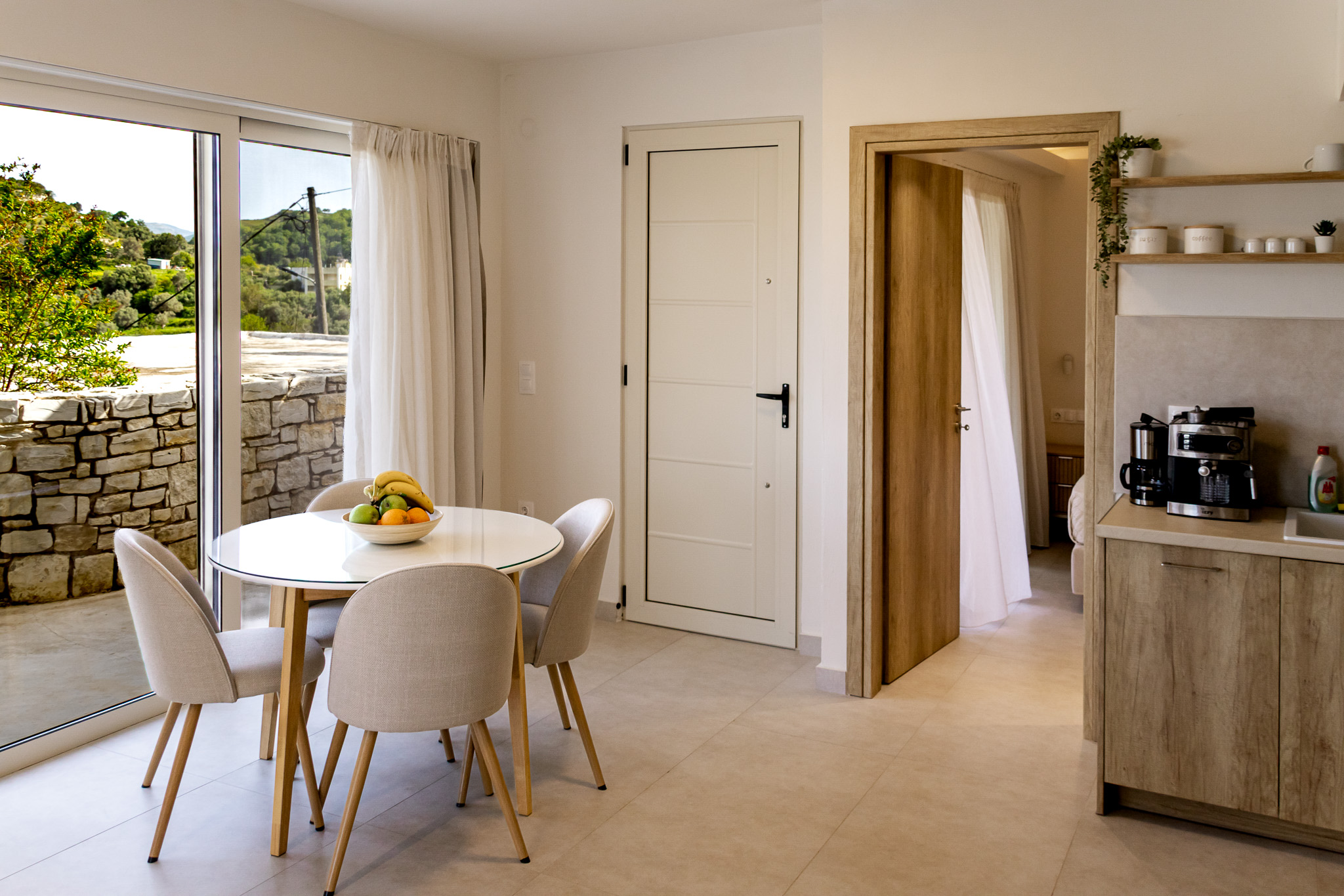 Living and dining area with kitchen, round table, and terrace doors